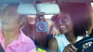 The Nexar Beam, one of the best dash cams, mounted in the front windshield of a car full of people